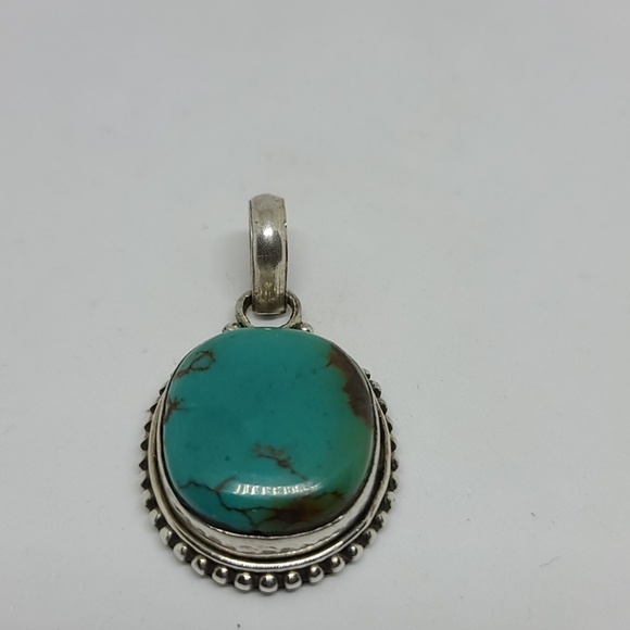 Genuine turquoise and sterling silver pendant.